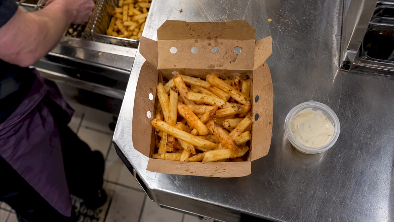 Pommes in einer belüfteten Take-away-Box mit Soßendip